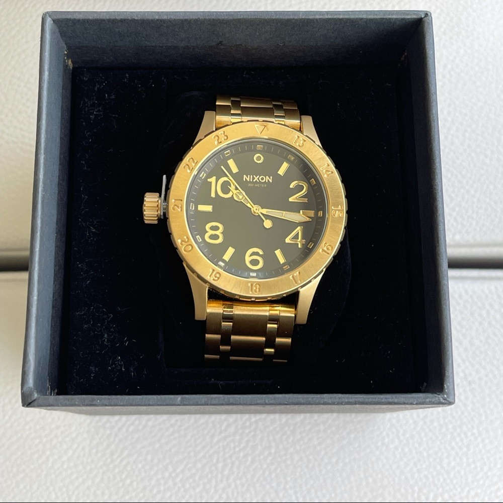 Women’s gold Nixon watch.
